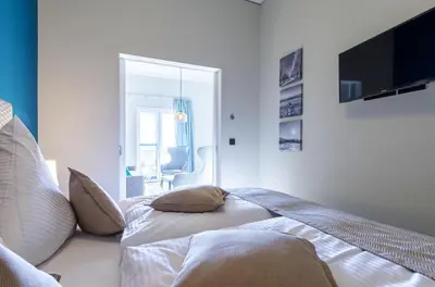 Ein Bett oder Betten in einem Zimmer der Unterkunft James Cook Suite - 2 Schlafzimmer, 2 Bäder, Boddenblick & Sauna