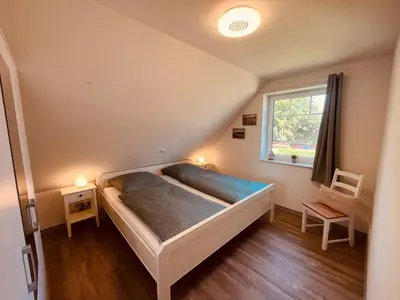 Ein Bett oder Betten in einem Zimmer der Unterkunft Holmblick - Boddenblick, Balkon, 2 Schlafzimmer, 4 Personen