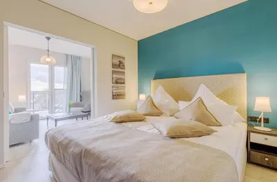 Ein Bett oder Betten in einem Zimmer der Unterkunft Sommerperle - 5-Sterne Ferienwohnung im Strandhaus-Stil mit Wellnessbereich und Ostseeblick