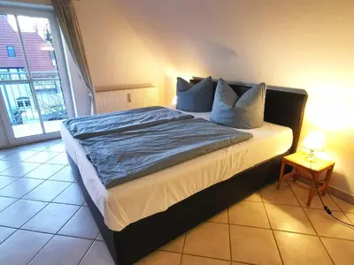 Ein Bett oder Betten in einem Zimmer der Unterkunft UNSERE 1-RAUM-PERLE FÜR ZWEI MIT BALKON im Bernsteinhaus Zingst - 8 -