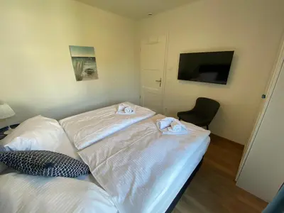 Ein Bett oder Betten in einem Zimmer der Unterkunft Friesia Urlaub unterm Reetdach fuer 4 Pers Terrasse Garten 2 SZ