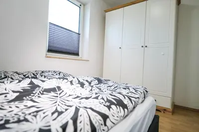 Ein Bett oder Betten in einem Zimmer der Unterkunft Ferienwohnungen Meerfarbig Zingst - HAUSTIERFREI -Terrasse mit Strandkorb oder Balkon - Glasfaser - Parkplatz - Fahrradschuppen - Waschtrockner - E-Ladesäule- ruhig und zentral - Nichtraucher